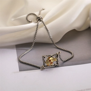 Detail of two-tone skull bracelet with red zircon eyes and adjustable pull-chain link