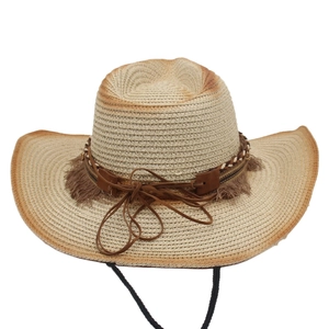 Detail of straw cowboy hat with gradient crown, ethnic woven band, and tassel trim