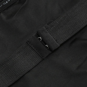 Gros plan du tissu en maille élastique noire et de la fermeture à crochet du pantalon