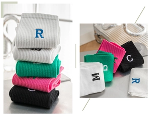 Detail view of cotton crew socks with athletic ribbing and embroidered letters R, M, and C