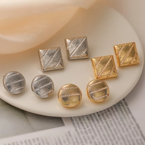 Goldene und silberne geometrische Ohrstecker mit Zirkonia-Besatz und strukturierter Oberfläche