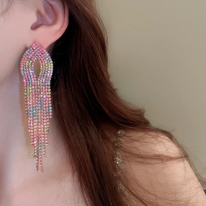Close-up of long tassel earrings with gradient rainbow rhinestones on a female model