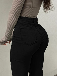 Detail shot of high-waisted black flared jeans showcasing back pockets and slim fit