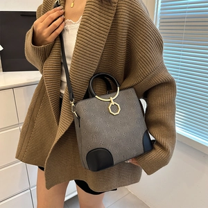Fashionable monogram printed bucket bag with gold hardware and leather handles in dark grey