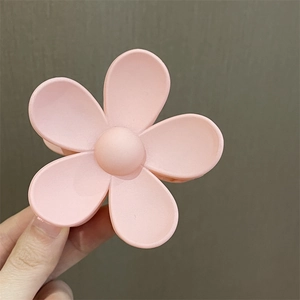 Detalle de pinza para el cabello de flor rosa mate con diseño de cinco pétalos
