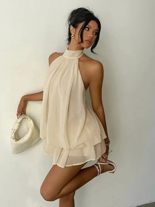 Detail of layered chiffon hem and halter neck design on a cream white mini dress