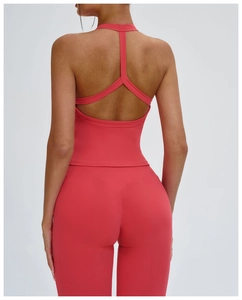 Dettaglio del top sportivo rosso corallo con maglia senza cuciture e tessuto traspirante