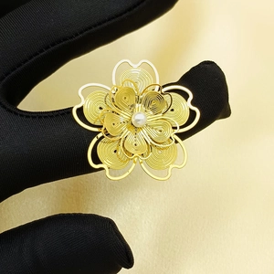 Three-dimensional gold flower ring with filigree petals and central white pearl accent