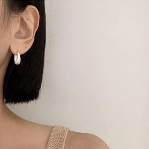 Elegant 925 sterling silver hoop earrings with twisted texture worn by model