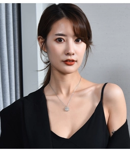 Silver four-leaf clover pendant necklace worn by a model on a delicate chain