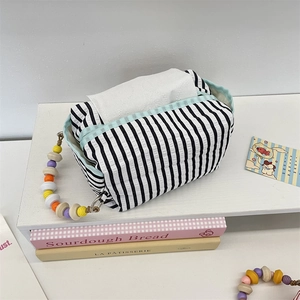 Detail of black and white striped fabric tissue box holder with colorful bead handle