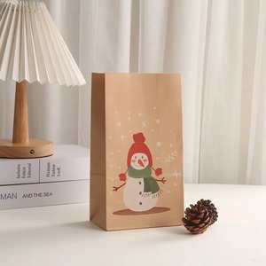 Detail of kraft paper gift bag featuring a festive snowman print for Christmas packaging