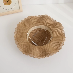 Detailed interior view of a children's straw sun hat featuring an adjustable white strap
