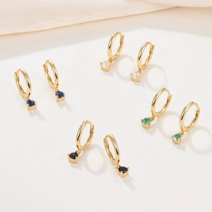 Golden huggie hoop earrings with colorful round zirconia charms in multiple sets