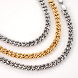 Close-up of classic silver and gold Cuban link chains with polished flat circular rings