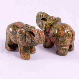 Macro detail of polished green and red stone elephant figurines with natural texture