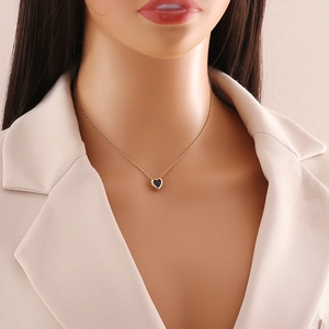 Detail shot of heart pendant necklace in gold finish worn by model for fashion preview