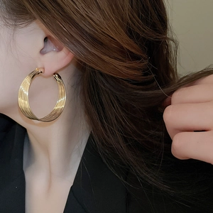 Close-up of gold layered hoop earrings on model featuring elegant metallic luster