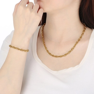 Close-up of gold-plated twisted rope chain necklace and bracelet worn by a model