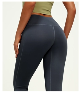 Detail of high-waist flared yoga pants with peach-butt seam and smooth charcoal fabric