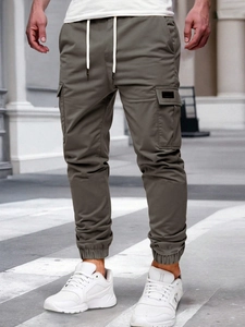 Detail of cargo pants with elastic drawstring waist and large side flap pockets