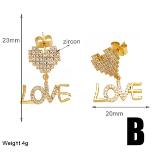 Detail view of 23mm gold heart earrings with LOVE pendant and zircon inlay
