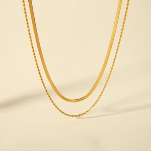 Close-up of golden stainless steel layered set featuring snake and twisted rope chains