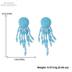 Detail view of light blue raffia tassel earrings with dimensions 8.7cm by 2.4cm