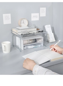 Clear acrylic desktop shelf detail with dual white drawers for stationery and books