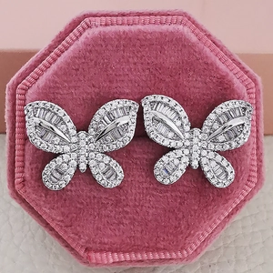 Macro shot of silver butterfly earrings with sparkling zircon inlay in a pink velvet box