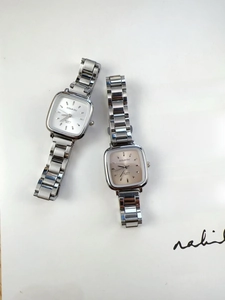 Detailed view of silver luxury square quartz watches with white and champagne dials