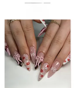 Close-up of French-style press-on nails with 3D bows, pearls, and lace patterns
