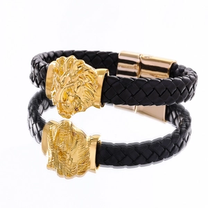 Close-up of black braided leather bracelet featuring a golden lion head and magnetic clasp