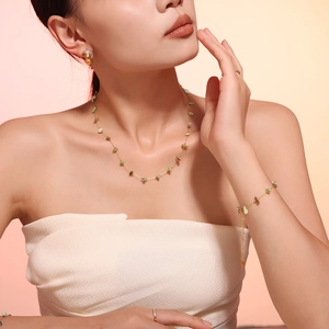 Détail d'un ensemble de bijoux bohèmes dorés avec pierres naturelles vertes sur un mannequin