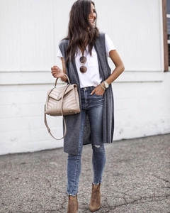 Modische graue lange Strickweste kombiniert mit einer beigen Handtasche und blauen Jeans