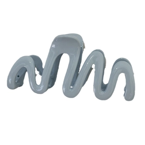 Glossy light blue wave hair claw clip with stylish curved design on white background