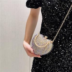 Macro shot of heart-shaped evening clutch with iridescent rhinestones and gold handle