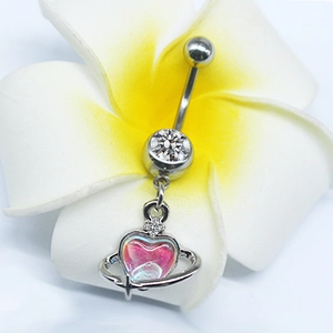 Macro shot of silver heart planet navel ring with iridescent stone on plumeria flower