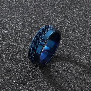 Detail view of blue stainless steel rotating chain ring with Roman numerals on black sand