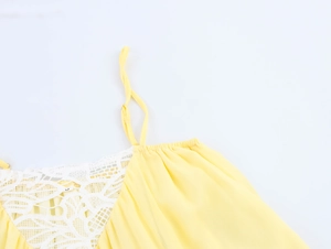 Détail du haut en mousseline jaune avec dentelle blanche et fines bretelles réglables