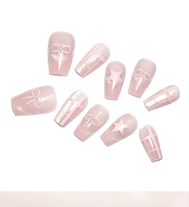 Detail of pink cat-eye press-on nails with 3D bows, stars, and pearl embellishments
