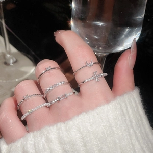 Close-up of a silver ring set with pearls and zircons worn on model's fingers