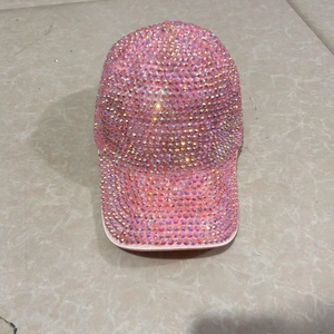 Close-up of pink AB rhinestones on a sparkling sequin baseball cap for stage dance