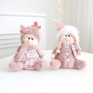 Detail of plush Christmas gnomes in pink and white with reindeer antlers and knit scarves