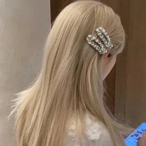Close-up of sparkling oval zircon hair clips on model's hair for elegant styling