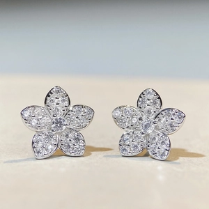 Makro-Detail von S925 Silber Blumenohrringen mit Vollbesatz aus Diamanten und Textur