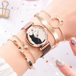 Close-up of golden cat-themed quartz watch and matching bracelets on woman's wrist