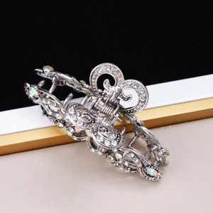 Detailed view of silver hollowed hair claw clip with colorful rhinestones and floral pattern