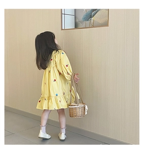 Vue détaillée du dos de la robe jaune brodée avec un panier en osier