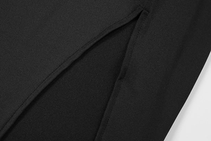 Macro detail of high-density black fabric stitching and slit hem workmanship